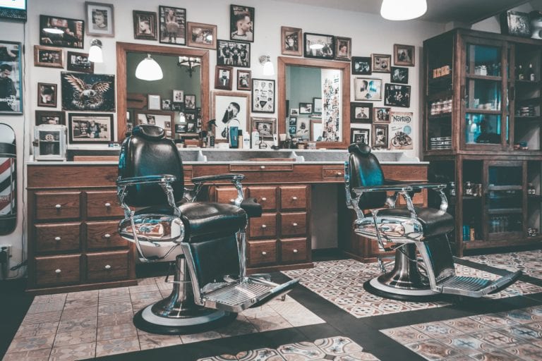 An old-school barber shop with mirrors, chairs, and photos.