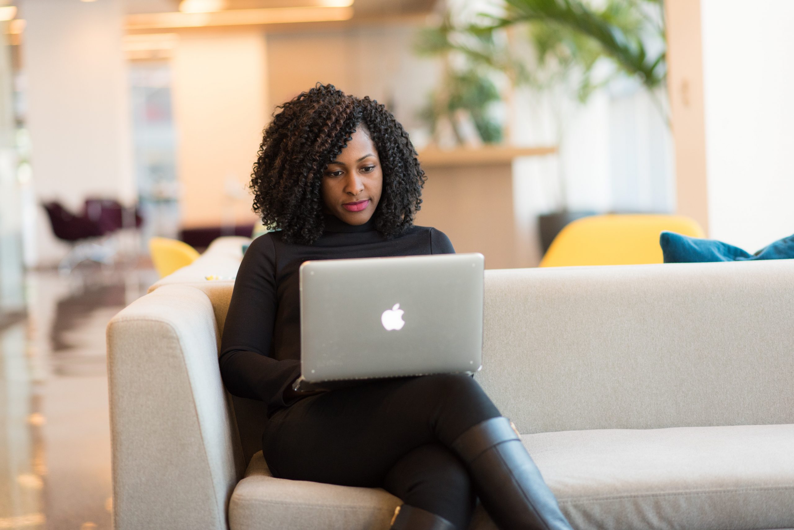 woman sitting on couch and using laptop