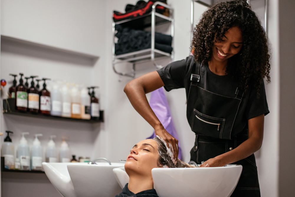 woman washing another woman's hair in a salon