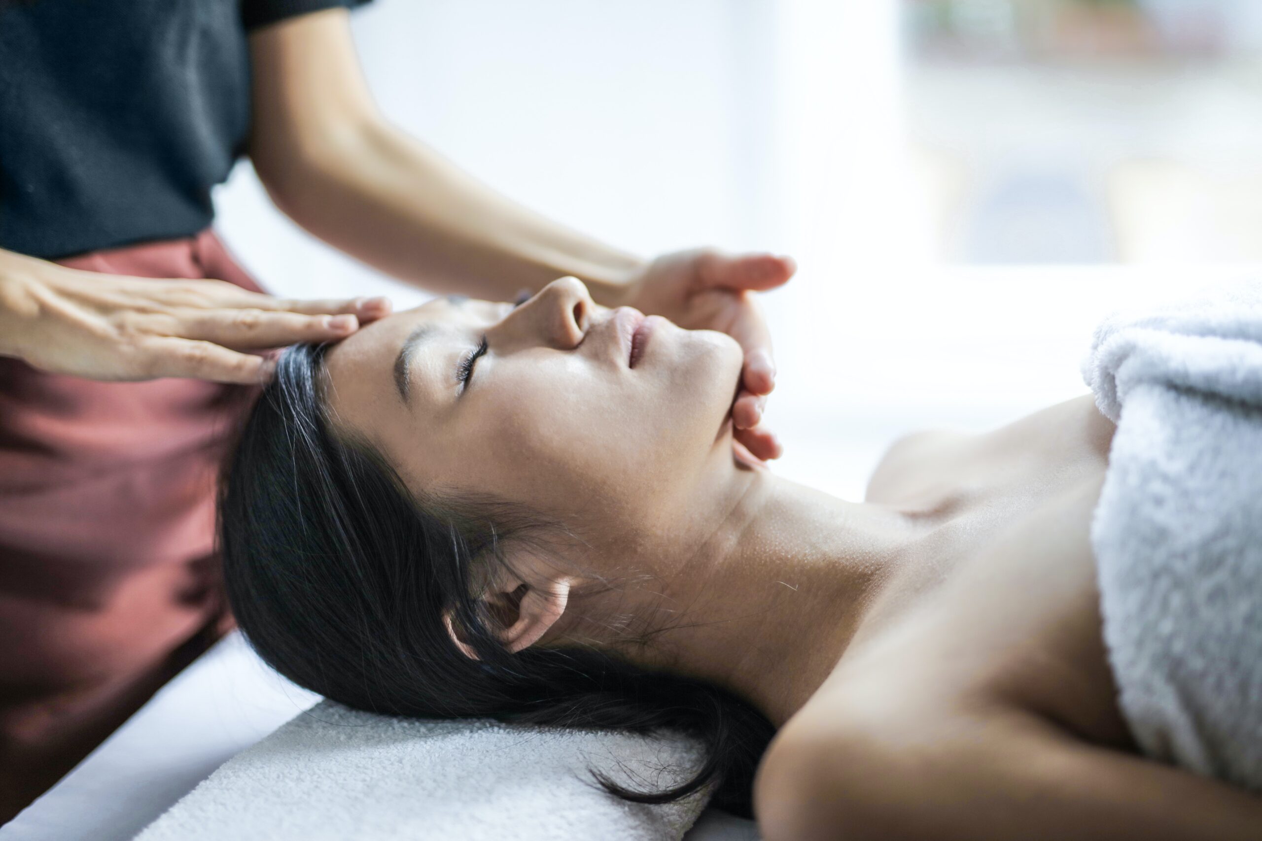 woman receiving facial massage at a spa