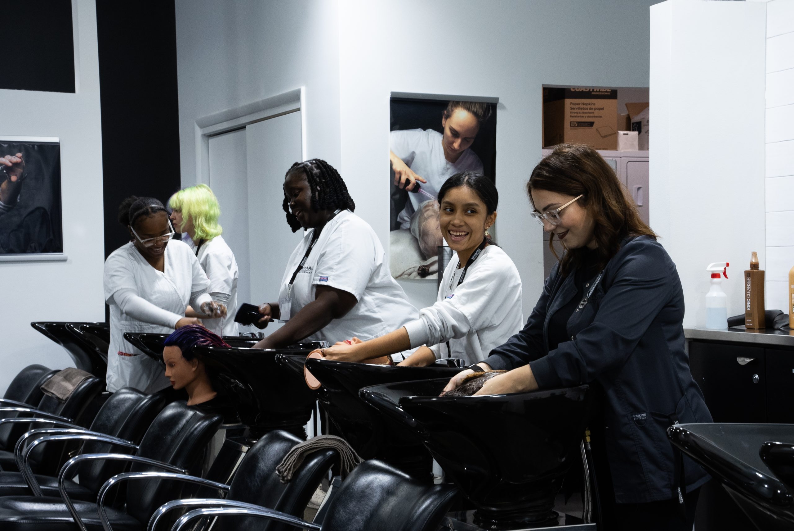 students at innovate salon academy washing mannequins hair