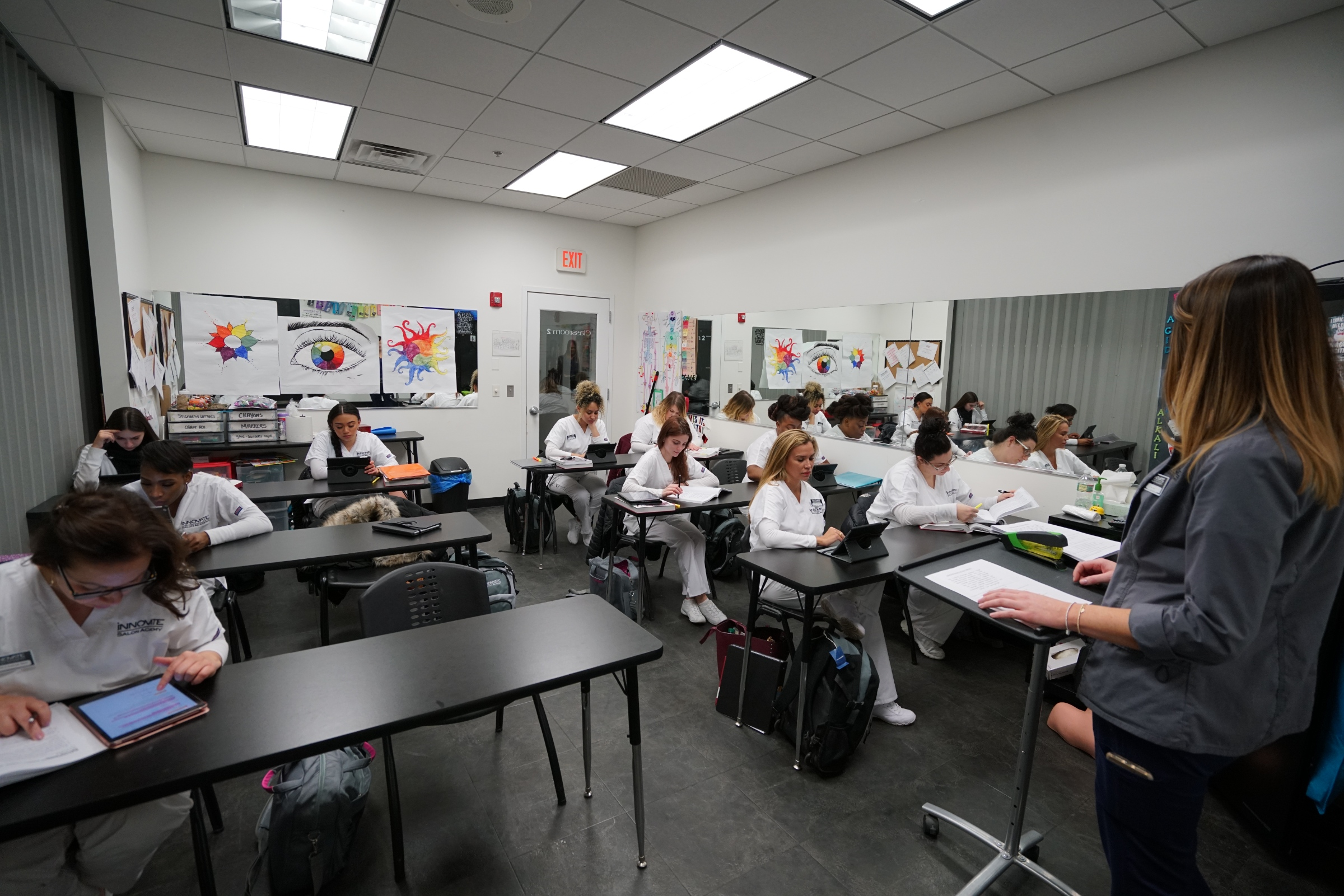 Students in a classroom at Innovate Salon Academy learning from an instructor